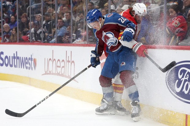 Ross Colton (20) of the Colorado Avalanche fights for the puck against Chris Tanev (8) of the Calgary Flames in the second period at Ball Arena on November 25, 2023 in Denver, Colorado. (Photo by Matthew Stockman/Getty Images)