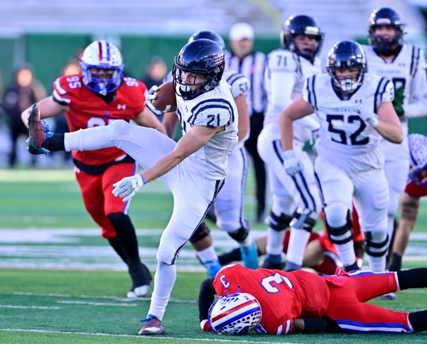 Columbine Rebels RB Josh Snyder (21) leaps over Cherry Creek Bruins CB Kiyon Johnston (3) and heads to the end zone for a touchdown in the second quarter of the 5A Colorado State Championship football game at Canvas Stadium in Ft. Collins on Saturday, Dec. 2, 2023. (Photo by Andy Cross/The Denver Post)