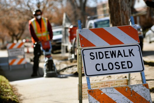 A neighborhood sidewalk repair crew works on a sidewalk repair on January 7, 2020, in Denver.
