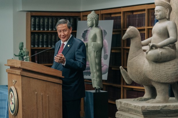 Keo Chhea, the Cambodian ambassador to the United States, speaks at an event that celebrated the return of 30 antiquities to Cambodia, in New York, Aug. 8, 2022. Chhea urged collectors, dealers and museums to intensify their efforts to review whether items they hold might have been stolen by looters. At right is the statue 